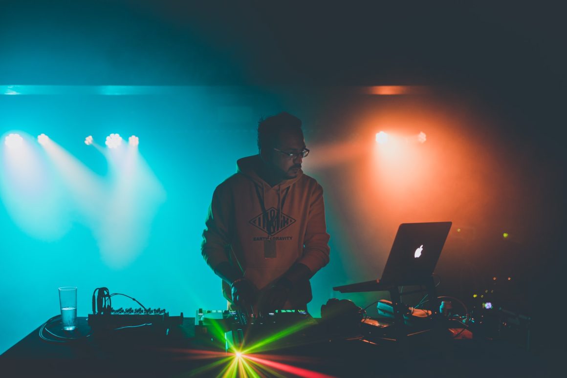 dj jamming with lights in the background